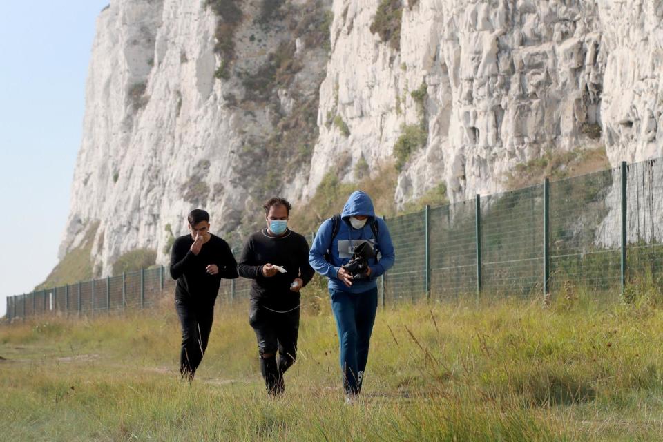 A group of people thought to be migrants on the coastline by the White Cliffs of Dover, Kent, after crossing the English Channel by small boat (PA)