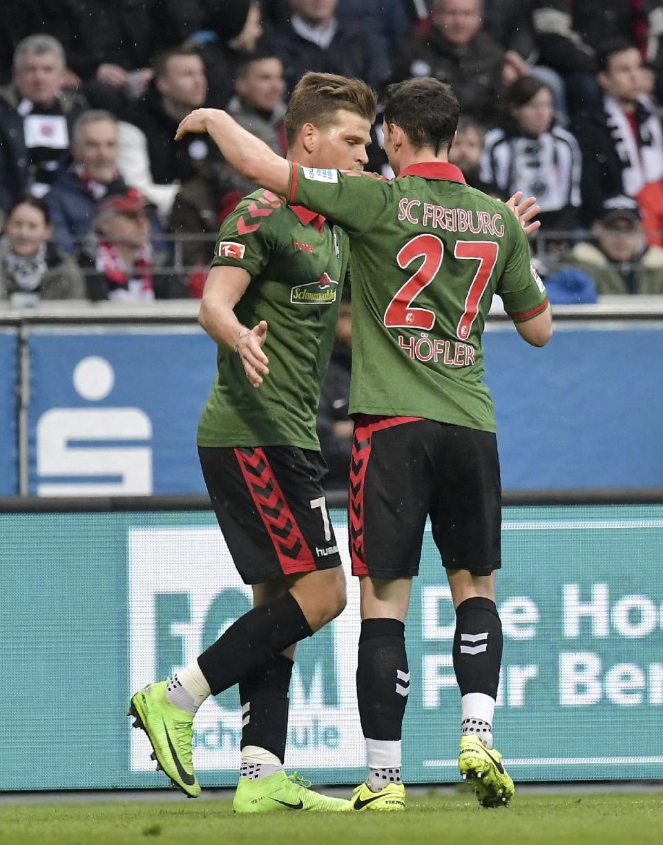 Freiburg's Florian Niederlechner, left, celebrates his goal with Nicolas Hoefler, right, during the Bundesliga soccer match between Eintracht Frankfurt and SC Freiburg at the Commerzbank Arena in Frankfurt, Germany, Sunday March 5, 2017. (Thorsten Wagner/dpa via AP)