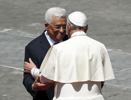 Pope Francis (R) embraces Palestinian President Mahmoud Abbas at the end of the ceremony for the canonisation of four nuns at Saint Peter's square in the Vatican City, May 17, 2015. REUTERS/Tony Gentile