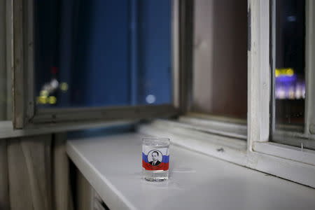 A vodka glass with a picture of Russian President Vladimir Putin is seen in this photo illustration taken in a hotel room in Kazan, Russia, July 31, 2015. REUTERS/Stefan Wermuth