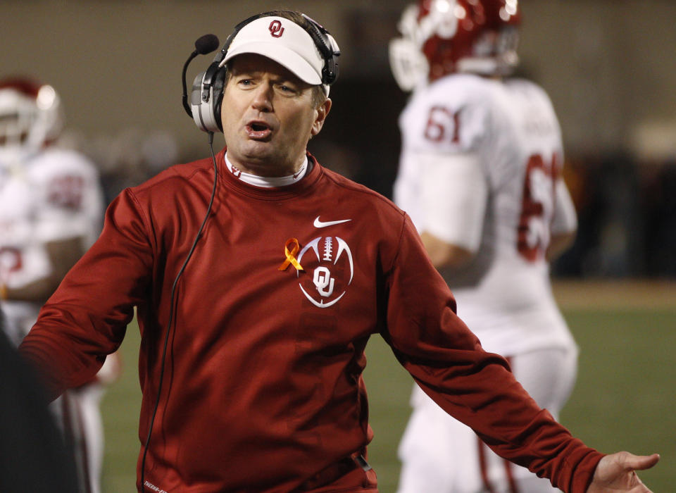 FILE - Oklahoma head coach Bob Stoops questions an official in the second quarter of an NCAA college football game against Oklahoma State in Stillwater, Okla., Dec. 3, 2011. (AP Photo/Sue Ogrocki, File)