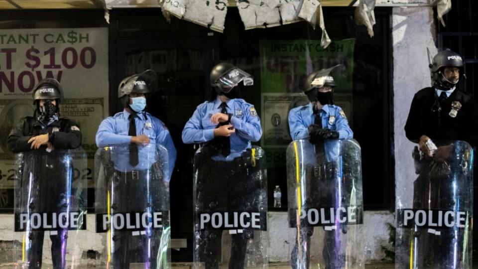 Philadelphia Police officers congregate an hour before a citywide curfew Wednesday night after two consecutive nights of unrest in response to the fatal shooting of 27-year-old Walter Wallace Jr., a father of nine children. (Photo by Mark Makela/Getty Images)