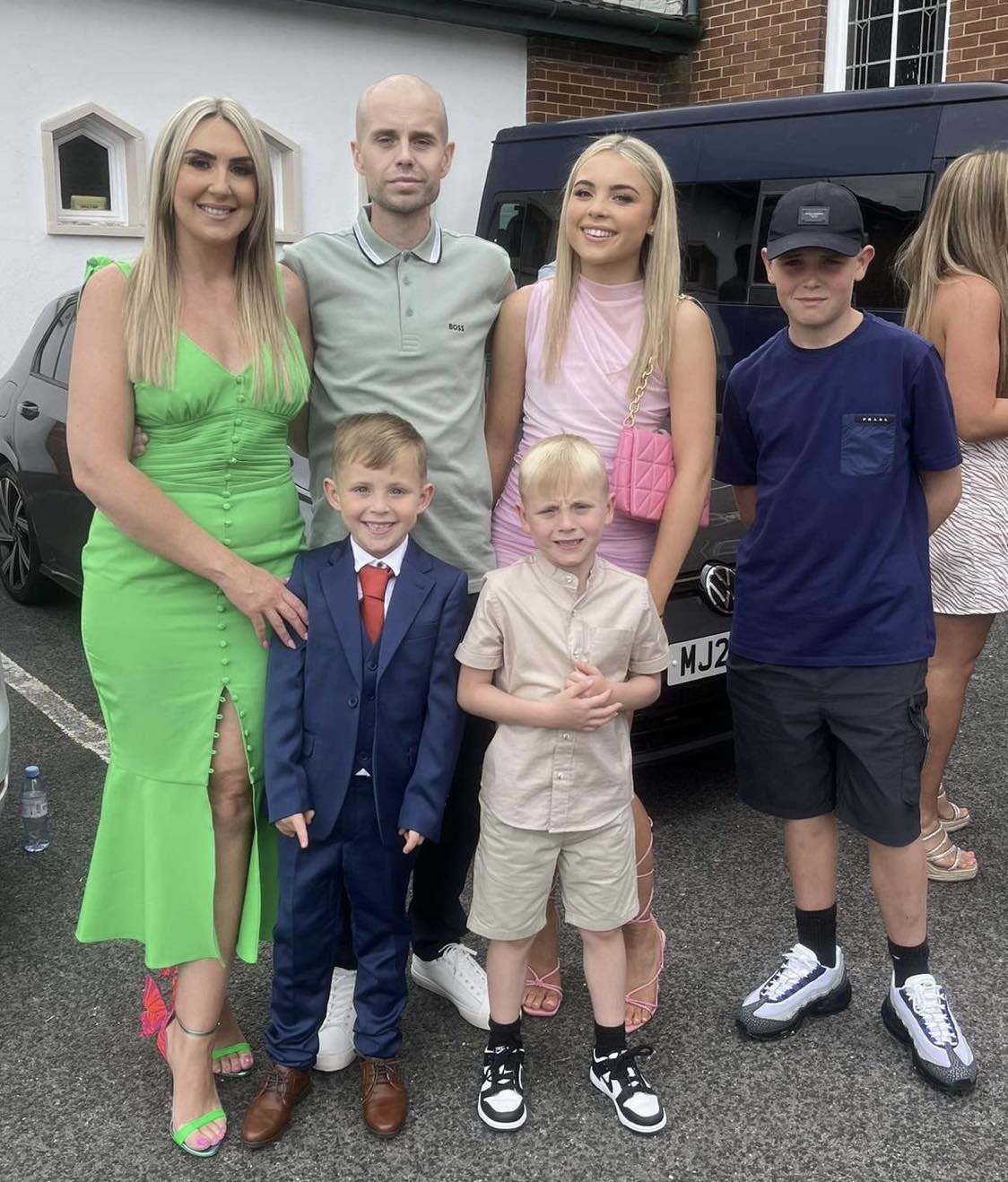 A photo of Andrew Harrison with his wife and four children standing next to him