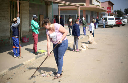 Locals clean up after over-night looting, when protesters took to the streets to demonstrate the killing of a boy in Coligny, North West province, South Africa, April 26, 2017. REUTERS/Siphiwe Sibeko