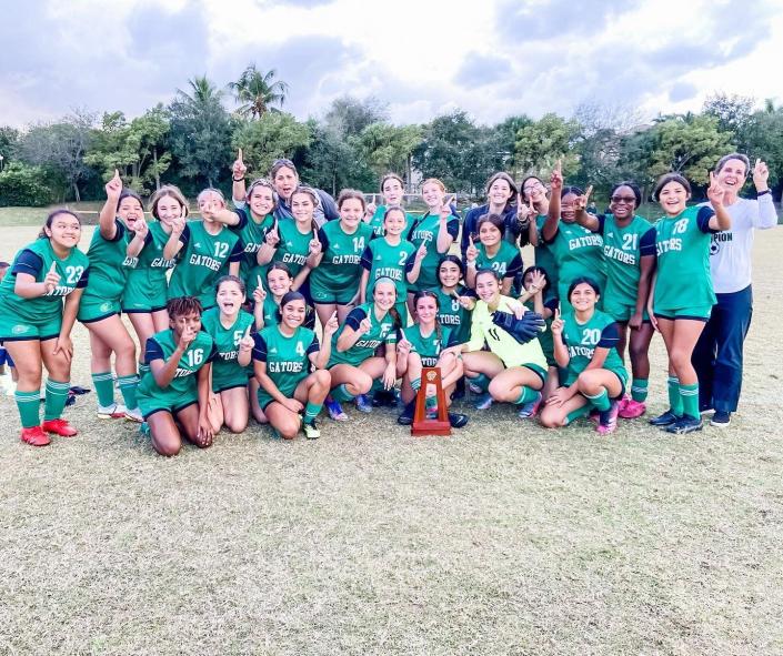 Glades Day girls soccer poses together to celebrate their district championship and defeating Lake Worth Christian for the first time since 2015 on Feb. 2, 2022.