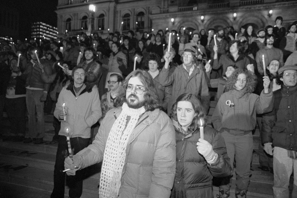 A crowd of mourners holds a candlelight vigil for John Lennon in 1980.