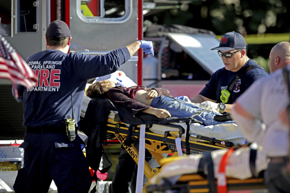 Medical personnel tend to a victim following a shooting at Marjory Stoneman Douglas High School in Parkland, Florida. (John McCall/South Florida Sun-Sentinel via AP)