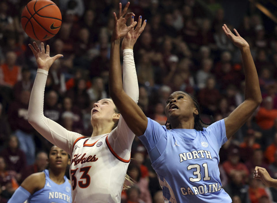 Virginia Tech's Elizabeth Kitley (33) reaches for an offensive rebound with North Carolina's Anya Poole (31) during the second half of an NCAA college basketball game in Blacksburg Va. Sunday, Feb. 25, 2024. (Matt Gentry/The Roanoke Times via AP)