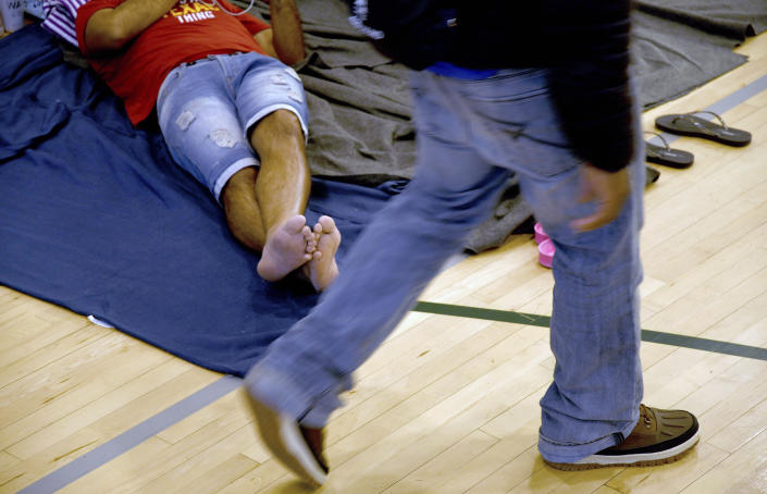 A migrant rests at a makeshift shelter in Denver on Friday, Jan. 6, 2023. Over the past month, nearly 4,000 immigrants, almost all Venezuelans, have arrived unannounced in the frigid city, with nowhere to stay and sometimes wearing T-shirts and flip-flops. In response, Denver converted three recreation centers into emergency shelters for migrants and paid for families with children to stay at hotels, allocating $3 million to deal with the influx. (AP Photo/Thomas Peipert)