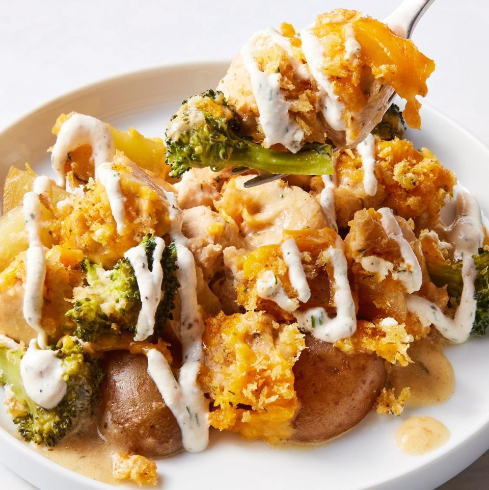 chicken with potatoes, broccoli, melted cheese, and drizzled with ranch in a casserole dish