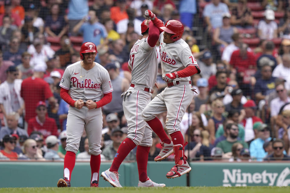 Philadelphia Phillies' Ronald Torreyes, right, celebrates his three-run home run with Rhys Hoskins, center, and Brad Miller, left, in the fourth inning of a baseball game against the Boston Red Sox, Sunday, July 11, 2021, in Boston. (AP Photo/Steven Senne)