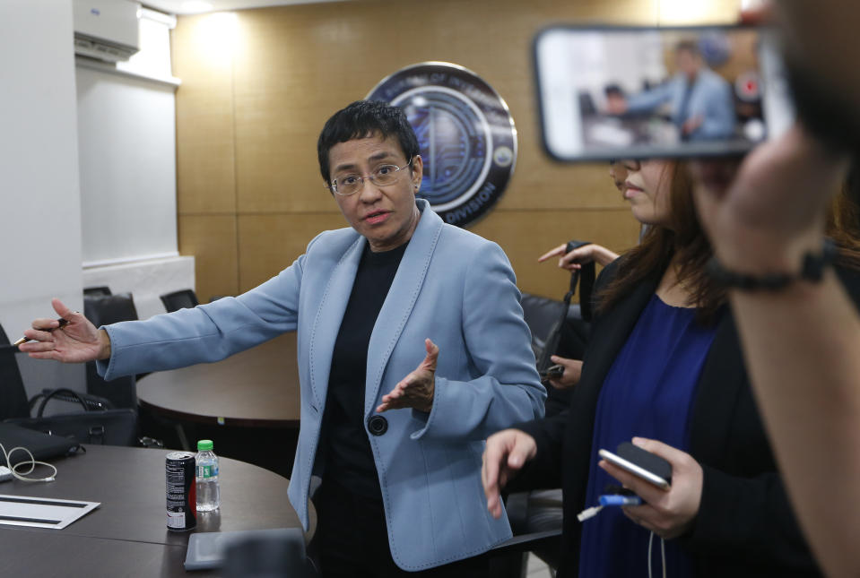 Maria Ressa, the award-winning head of a Philippine online news site Rappler that has aggressively covered President Rodrigo Duterte's policies, gestures while talking to the media after being arrested by National Bureau of Investigation agents in a libel case Wednesday, Feb. 13, 2019 in Manila, Philippines. Ressa, who was selected by Time magazine as one of its Persons of the Year last year, was arrested over a libel complaint from a businessman which Amnesty International has condemned as "brazenly politically motivated." Duterte's government says the arrest was a normal step in response to the complaint. (AP Photo/Bullit Marquez)