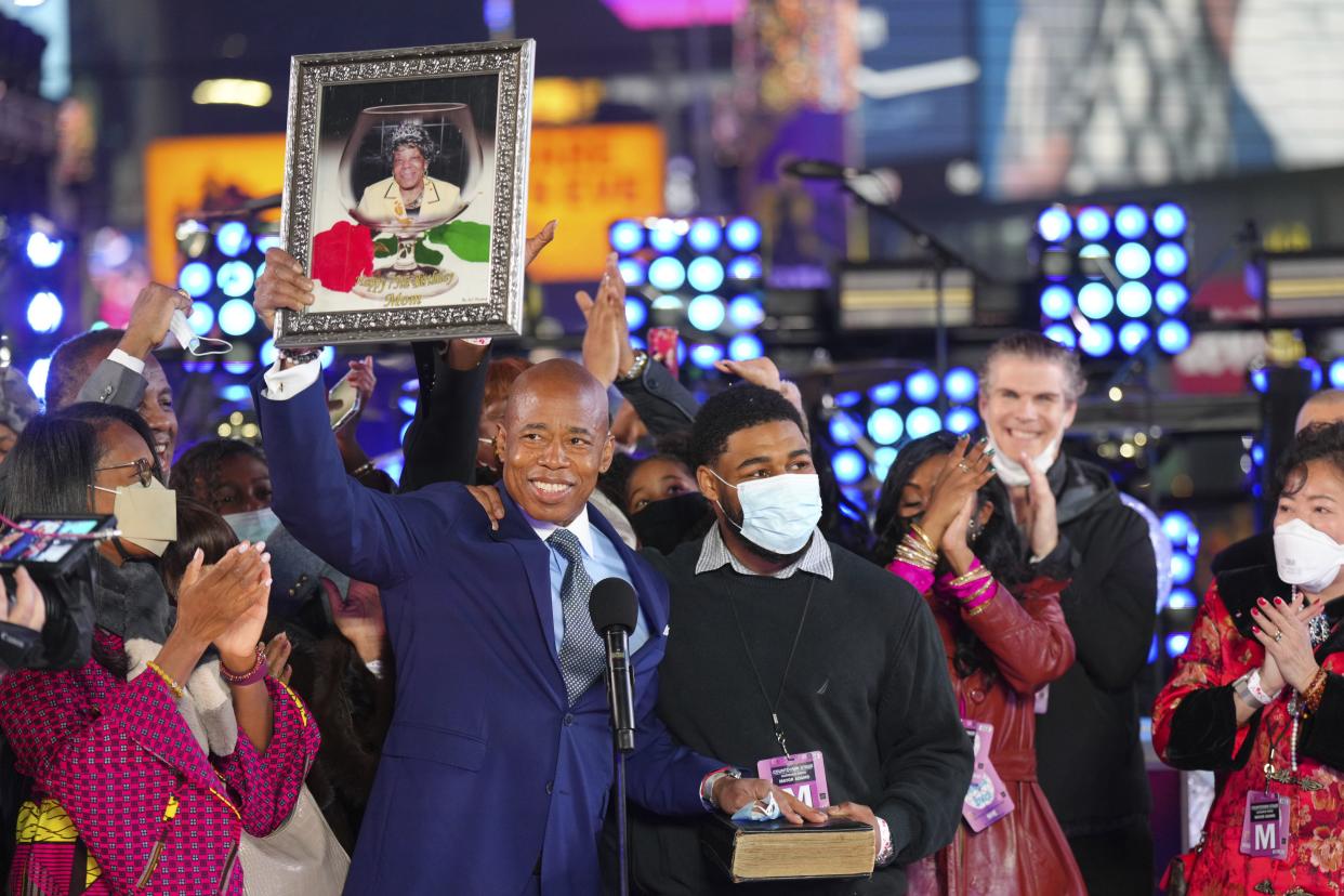 New York City Mayor Eric Adams holds up a framed photo of his mother at his swearing-in during the Times Square New Year's Eve celebration early Sunday, Jan. 1, 2022, in Manhattan, New York. 