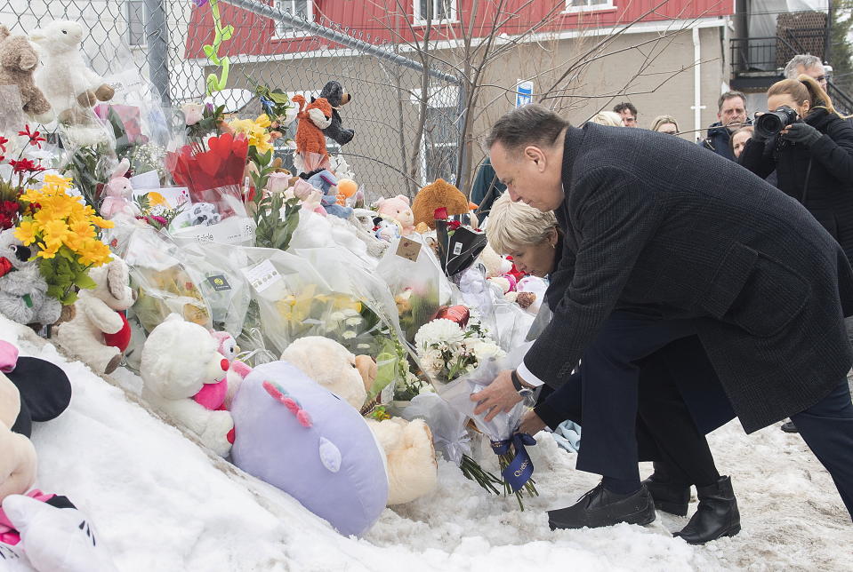 Quebec Premier Francois Legault lays flowers as he visits the site of a daycare centre in Laval, Quebec, Thursday, Feb. 9, 2023, where a city bus crashed into the building killing two children. (Graham Hughes/The Canadian Press via AP)