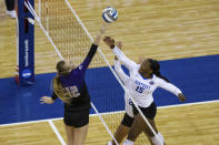 Washington's Marin Grote (12) bumps the ball over Kentucky's Azhani Tealer (15) during the first set of a semifinal in the NCAA women's volleyball championships Thursday, April 22, 2021, in Omaha, Neb. (AP Photo/John Peterson)