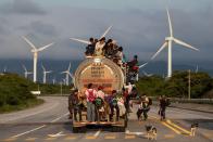 <p>A truck carrying mostly Honduran migrants taking part in a caravan heading to the U.S. passes a wind farm on the way from Santiago Niltepec to Juchitan, near the town of La Blanca in Oaxaca State, Mexico, on Oct. 30, 2018. (Photo: Guillermo Arias/AFP/Getty Images) </p>