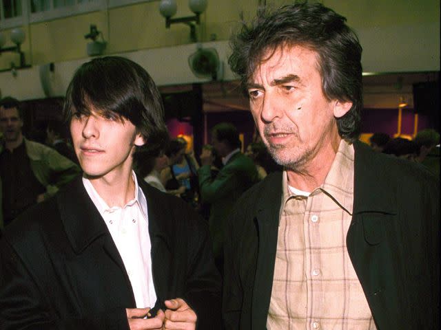 <p>Richard Young/Shutterstock</p> George Harrison and son Dhani Harrison at Christie's London for a guitar auction in 1999.