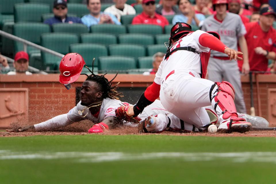 Cincinnati Reds' Elly De La Cruz, left, scores ahead of the tag from St. Louis Cardinals catcher Willson Contreras during the eighth inning of a baseball game Sunday, June 11, 2023, in St. Louis.