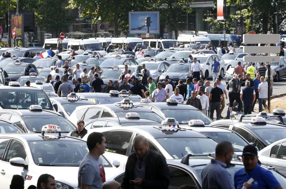 French taxi drivers, who are on strike, demonstrate at Porte Maillot to block the traffic on the Paris ring road during a national protest against car-sharing service Uber, in Paris, France, June 25, 2015. (REUTERS/Charles Platiau)