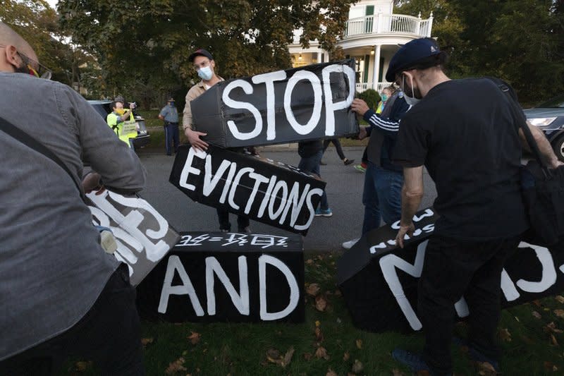 Housing activists erect a sign in front of Massachusetts Gov. Charlie Baker’s house, Wednesday, Oct. 14, 2020, in Swampscott, Mass. (AP Photo/Michael Dwyer, file)