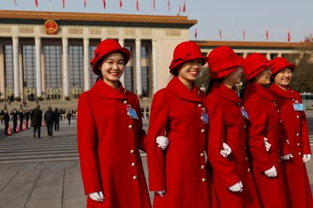 Hostesses pose in front of Great Hall of the People during the annual session of China's parliament, the National People's Congress (NPC), in Beijing, China March 4, 2017. REUTERS/Tyrone Siu