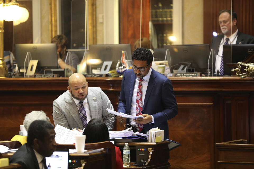 South Carolina Rep. John King, D-Rock Hill, left, and Rep. Justin Bamberd, D-Bamberg, right, look over amendments during the debate on a bill to ban transgender athletes from girls' and women's public school and college sports teams on Tuesday, April 5, 2022, in Columbia, S.C. (AP Photo/Jeffrey Collins)