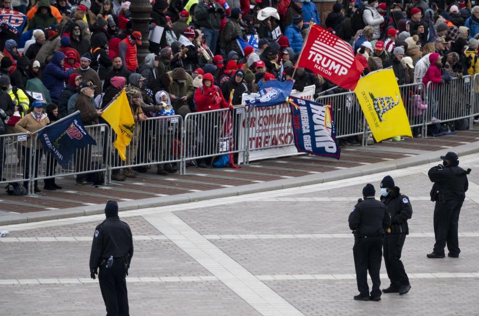 <span class="caption">Gadsden flags fly at a protest Wednesday at the Capitol.</span> <span class="attribution"><a class="link " href="https://www.gettyimages.com/detail/news-photo/capitol-police-line-the-barricades-as-trump-supporters-news-photo/1230452268" rel="nofollow noopener" target="_blank" data-ylk="slk:Bill Clark/CQ-Roll Call, Inc via Getty Images;elm:context_link;itc:0;sec:content-canvas">Bill Clark/CQ-Roll Call, Inc via Getty Images</a></span>
