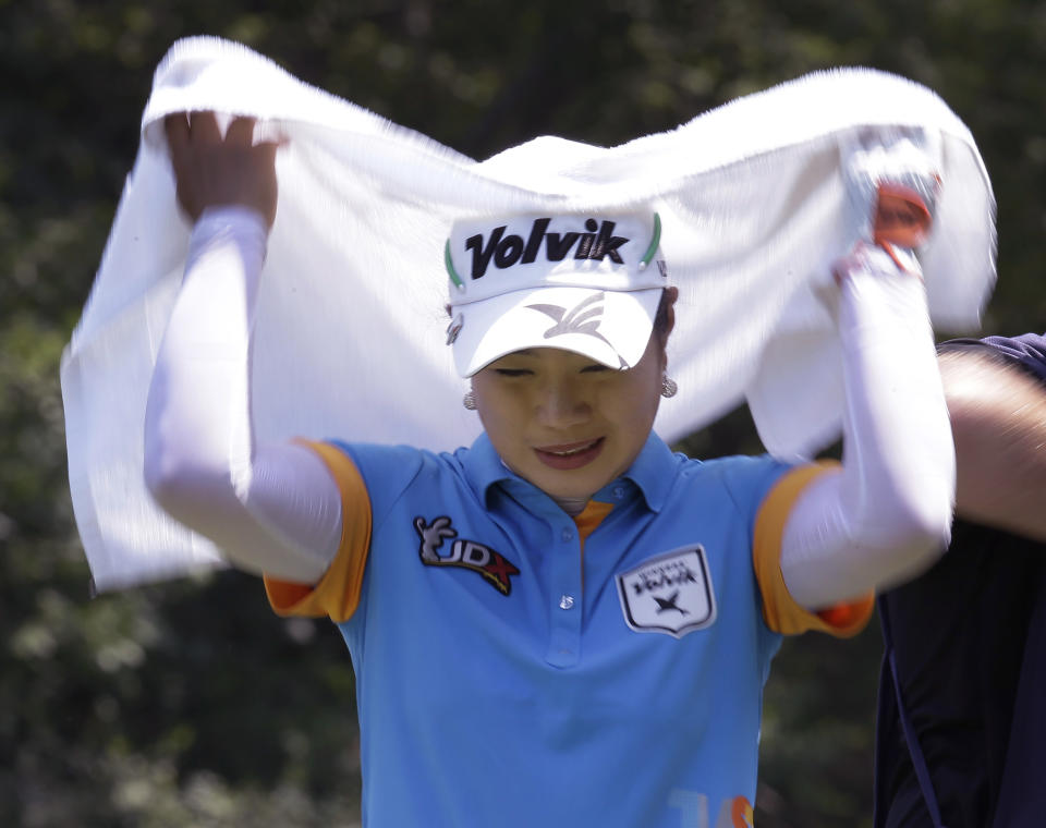 South Korea's Meena Lee covers her head with a towel to ward off sunshine, during the first round of the U.S. Women's Open golf tournament, Thursday, July 5, 2012, in Kohler, Wis. (AP Photo/Julie Jacobson)