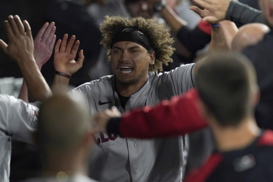 Cleveland Guardians' Josh Naylor celebrates his game-tying grand slam off Chicago White Sox relief pitcher Liam Hendriks in the dugout during the ninth inning of a baseball game Monday, May 9, 2022, in Chicago. (AP Photo/Charles Rex Arbogast)