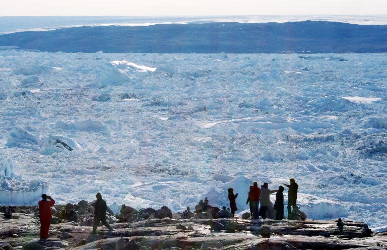 Tourists look out over the ice of the Ilulissat fjord on September 11, 2008 in Ilulissat, on the western coast of Greenland