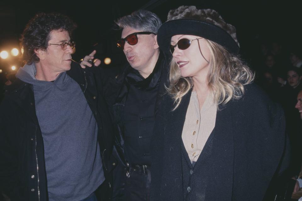 lou reed, chris stein, and debbie harry walk together, the men talk as harry smiles