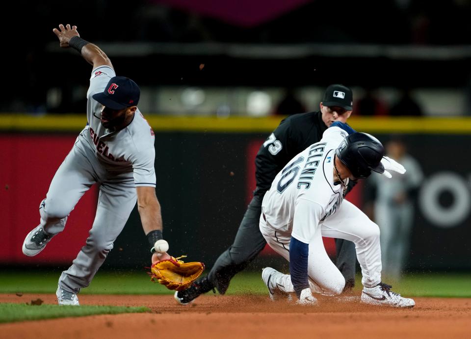 Seattle Mariners' Jarred Kelenic steals second base ahead of the tag from Cleveland Guardians shortstop Amed Rosario, left, during the fifth inning of an opening day baseball game Thursday, March 30, 2023, in Seattle. (AP Photo/Lindsey Wasson)