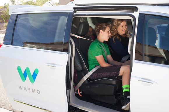 A boy and a woman in a Waymo minivan