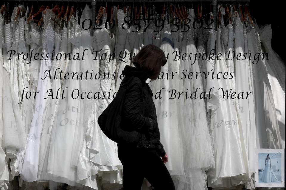 A woman walks past a Wedding dress shop in London, Tuesday, June 9, 2020, where bride dresses pile unused in the shop window. Weddings in the UK have been postponed due to the Covid-19 pandemic and are probably allowed starting in July. (AP Photo/Frank Augstein)