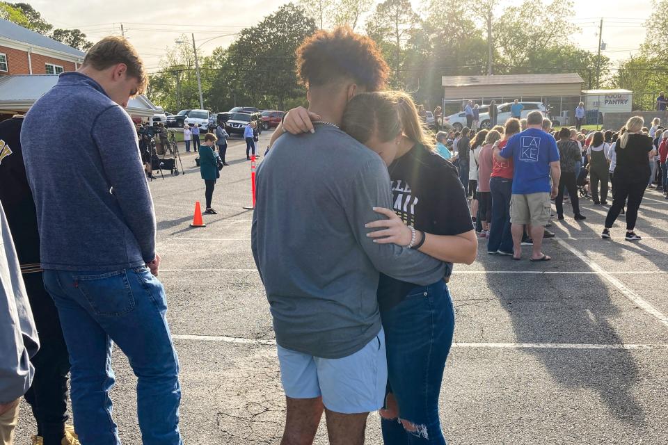 Two teens embrace at a prayer vigil on April 16, 2023, outside First Baptist Church in Dadeville, Ala.