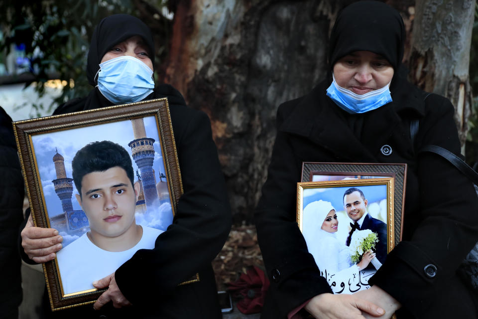 Relatives of victims of the Aug. 4, 2020 Beirut port explosion hold portraits of their loved one who killed during the explosion, during a sit-in outside the Justice Palace, in Beirut, Lebanon, Thursday, Feb. 18, 2021. Lebanon's highest court asked the chief prosecutor investigating last year's massive Beirut port explosion to step down, following legal challenges by senior officials he had accused of negligence that led to the blast, a judicial official and the country's official news agency said. (AP Photo/Hussein Malla)