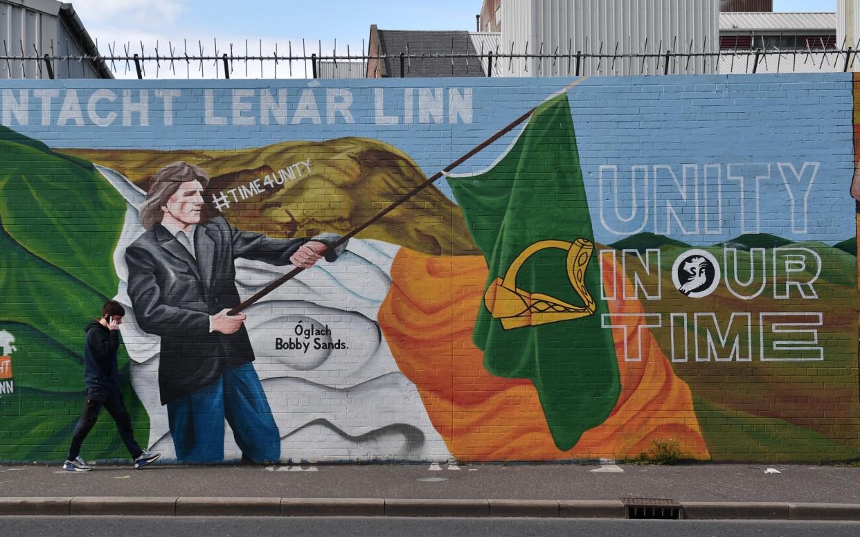 A man walks past a Sinn Fein mural calling for Irish unity, in Belfast in 2022