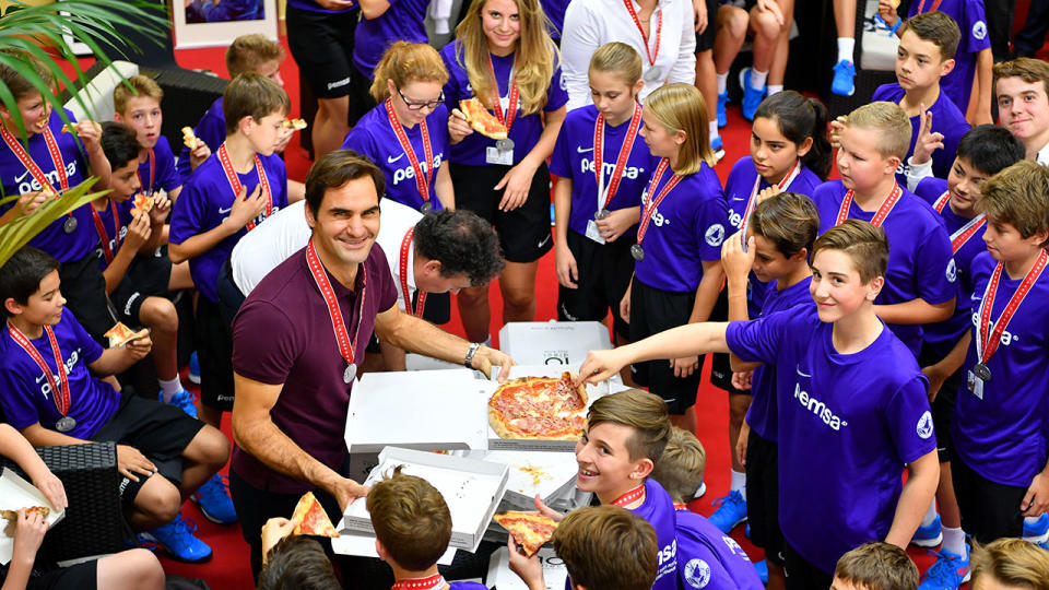 Roger Federer celebrates his victory with the tournament ballkids. (Photo by Harold Cunningham/Getty Images)