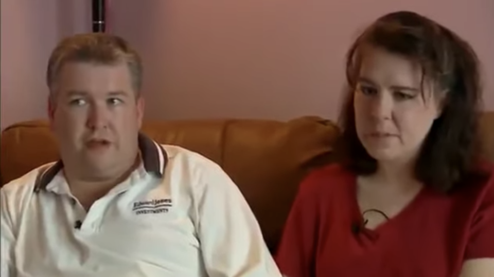 Couple sitting on their couch looking upset