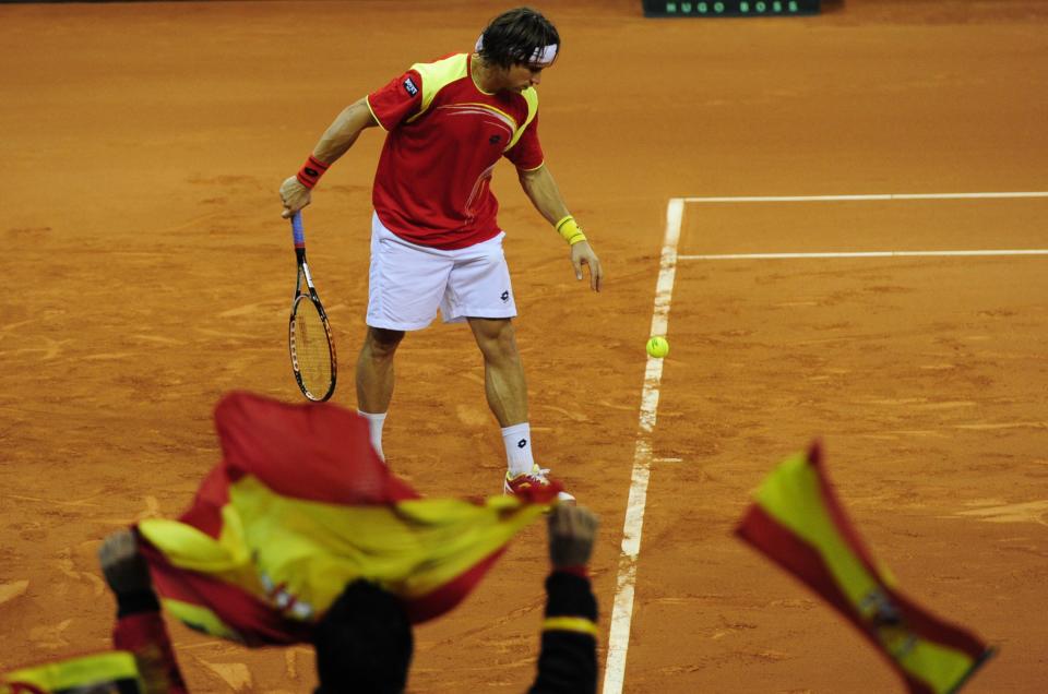 Supporters wave Spanish flags as Spanish David Ferrer prepares to serve to Argentinian Juan Martin Del Potro during their Davis Cup final second match at La Cartuja Olympic stadium in Sevilla on December 2, 2011. David Ferrer defeated Juan Martin del Potro 6-2, 6-7 (2/7), 3-6, 6-4, 6-3 in a marathon clash to give Spain a 2-0 lead over Argentina in the Davis Cup final.  AFP PHOTO / JAVIER SORIANO (Photo credit should read JAVIER SORIANO/AFP/Getty Images)