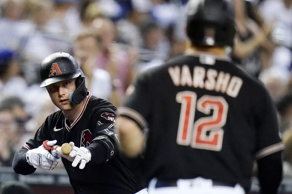 Arizona Diamondbacks' Christian Walker, left, celebrates a home run hit by Diamondbacks' Daulton Varsho (12) against the Los Angeles Dodgers during the first inning of a baseball game in Phoenix, Wednesday, Sept. 14, 2022. (AP Photo/Ross D. Franklin)