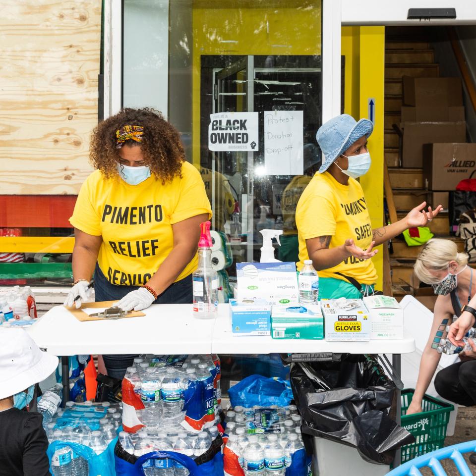 Volunteers help distribute food, water, and other donated supplies.