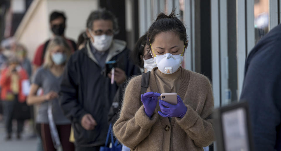 People wearing masks and using mobile phones