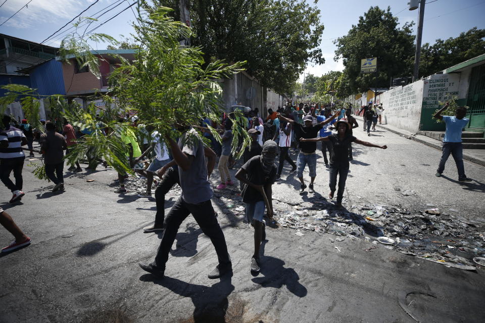 Haitians respond to a nationwide push to block streets and paralyze Haiti's economy as they press for President Jovenel Moise to give up power, in Port-au-Prince, Haiti, Monday, Sept. 30, 2019. Opposition leaders and supporters say they are angry about public corruption, spiraling inflation and a dwindling supply of gasoline that has forced many gas stations in the capital to close as suppliers demand the cash-strapped government pay them more than $100 million owed. (AP Photo/Rebecca Blackwell)