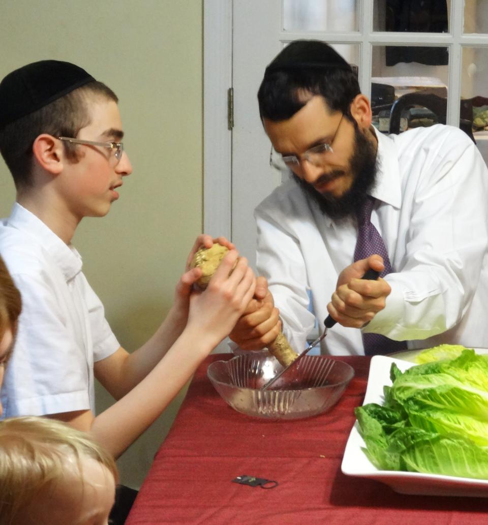 Ari and his father, Rabbi Schneur Oirechman, grate the bitter herb horseradish for the Seder.