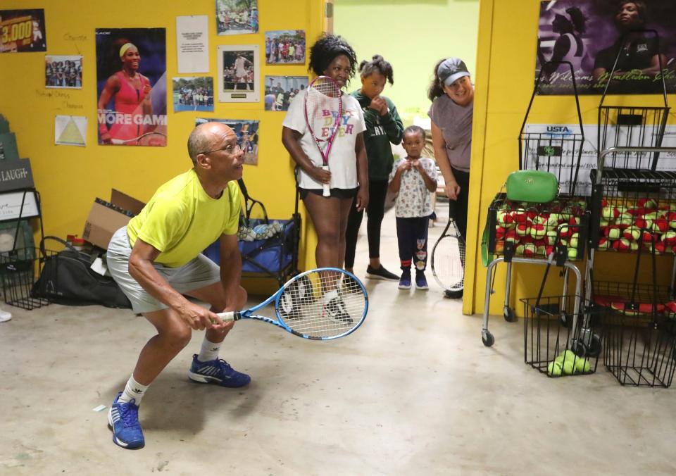 Jeff Collins works on returns with Chene Woodard, Kylee and Gregory Jackson and Maria Nederhood, at a shed located near the Palmer Park courts in Detroit on Aug. 18, 2022. Collins is using teaching tennis as a way to celebrate his late wife of 36 years, Lois Collins.