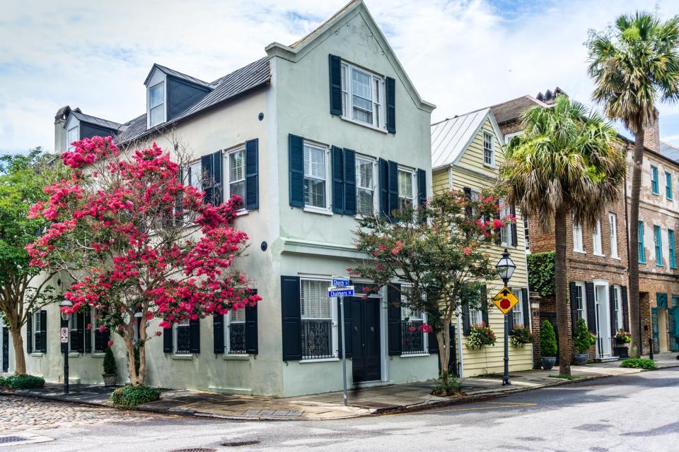 Buidings line Church Street in Charleston, South Carolina. Red flowers add color.