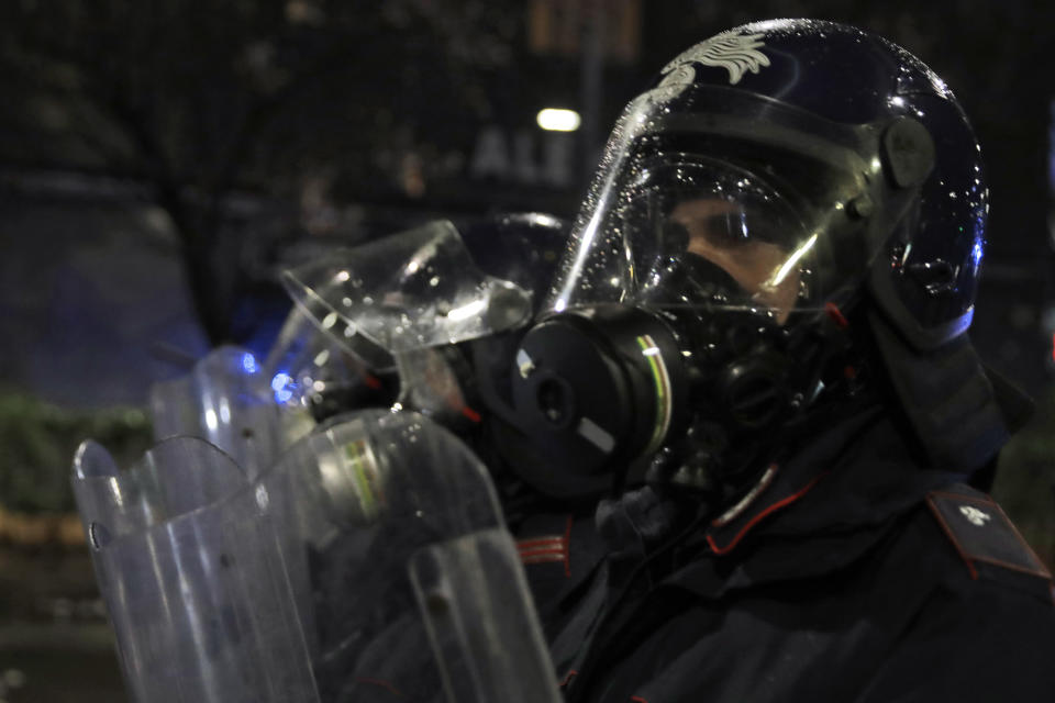 Riot Police officers line up during a protest against the government restriction measures to curb the spread of COVID-19, in Milan Italy, Monday, Oct. 26, 2020. Italy's leader has imposed at least a month of new restrictions to fight rising coronavirus infections, shutting down gyms, pools and movie theaters and putting an early curfew on cafes and restaurants. (AP Photo/Luca Bruno)