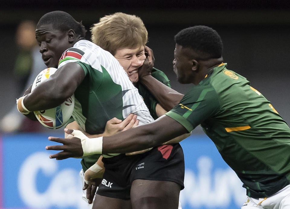 South Africa's Sakoyisa Makata, right, gets his hand to the face of teammate Christie Grobbelaar, back, as they tackle Kenya's Alvin Otieno during an HSBC Canada Sevens rugby game in Vancouver, British Columbia, Saturday, Sept. 18, 2021. (Darryl Dyck/The Canadian Press via AP)