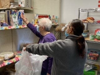 A volunteer assisting a client in the food room.